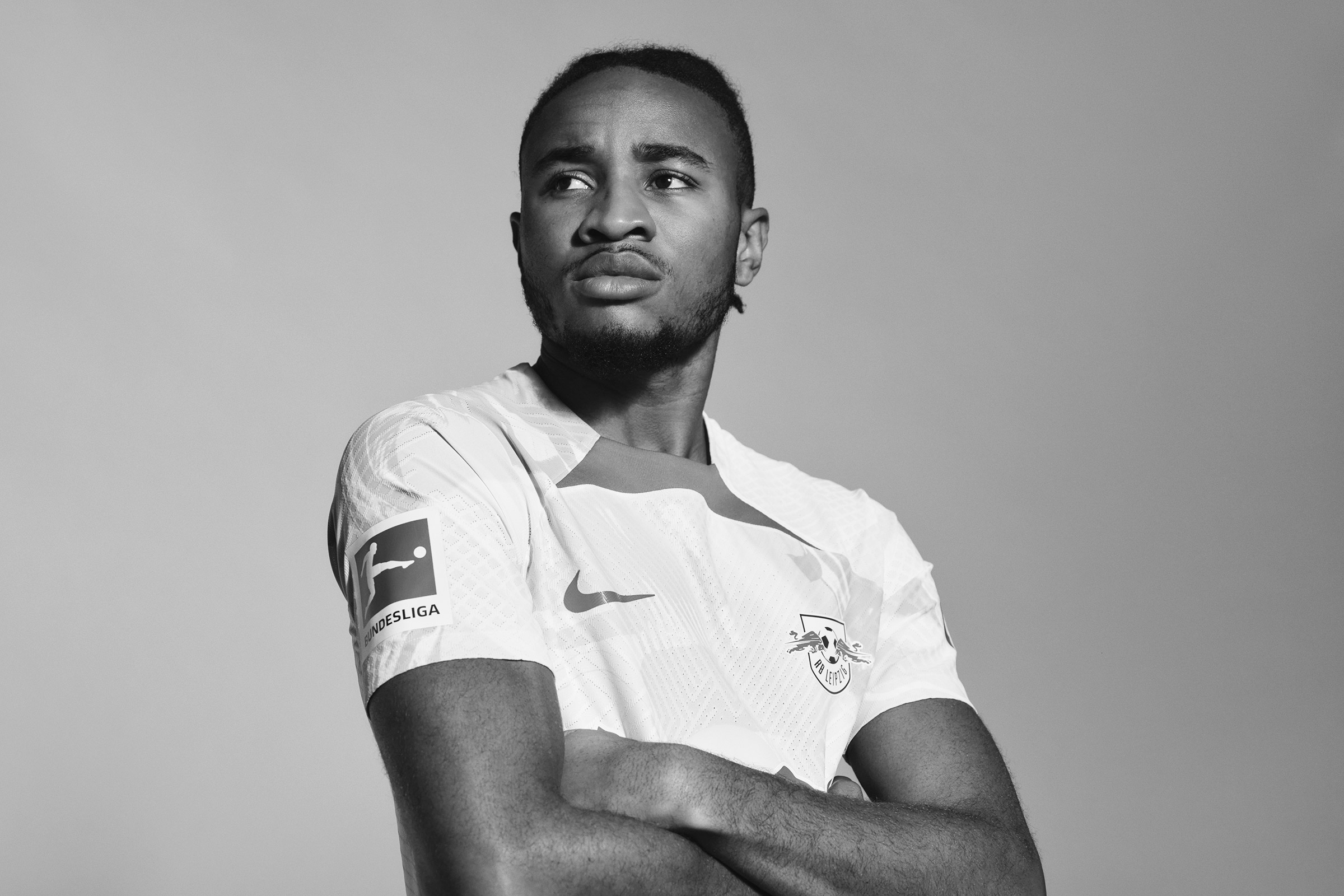 Christopher-Nkunku-Red-Bull-portrait-by-Robert Wunsch 2022 Christopher Nkunku posing with crossed arms.