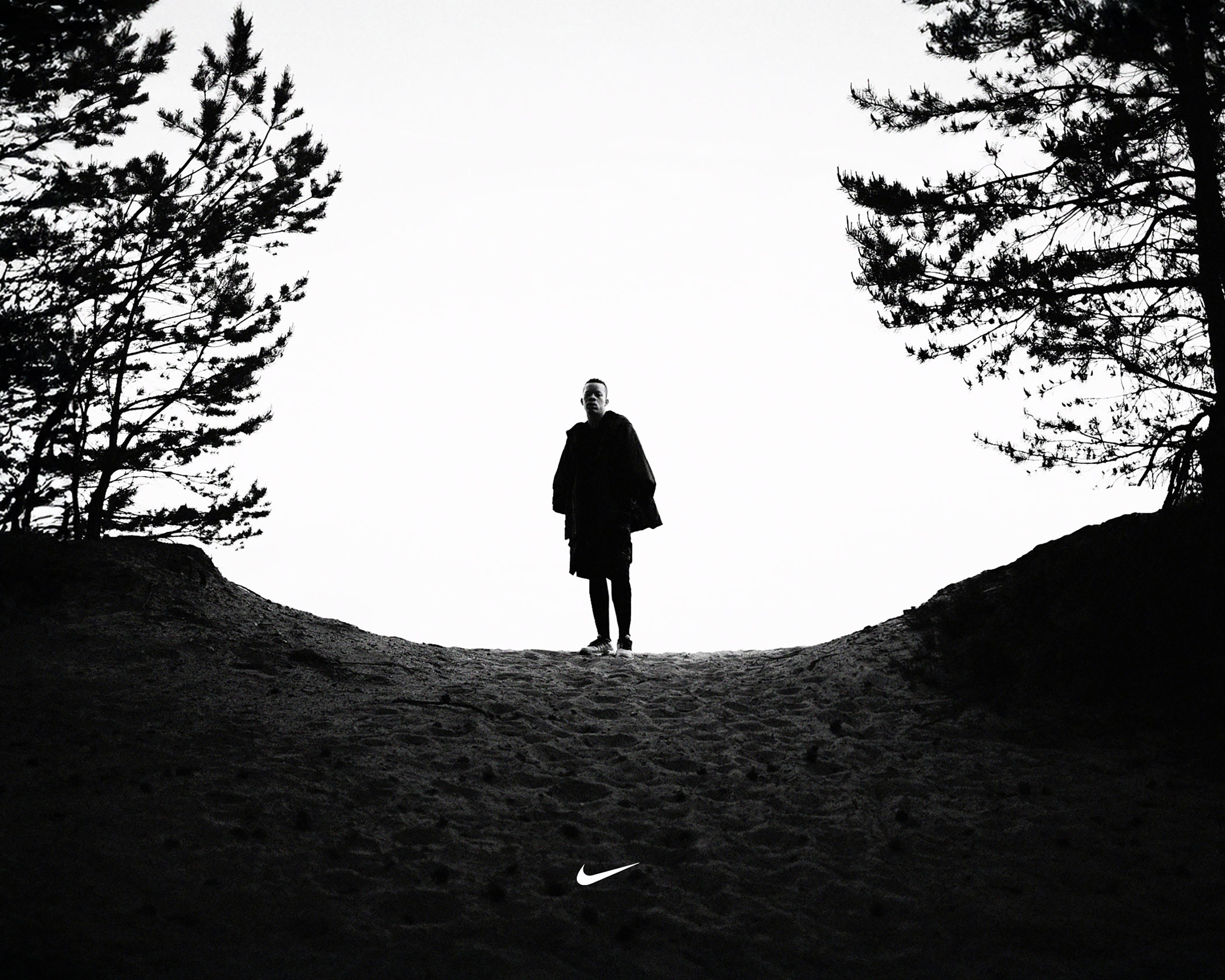 Nike-Running-by-Robert-Wunsch A runner on a hill between trees in black and white wearing Nike apparel.