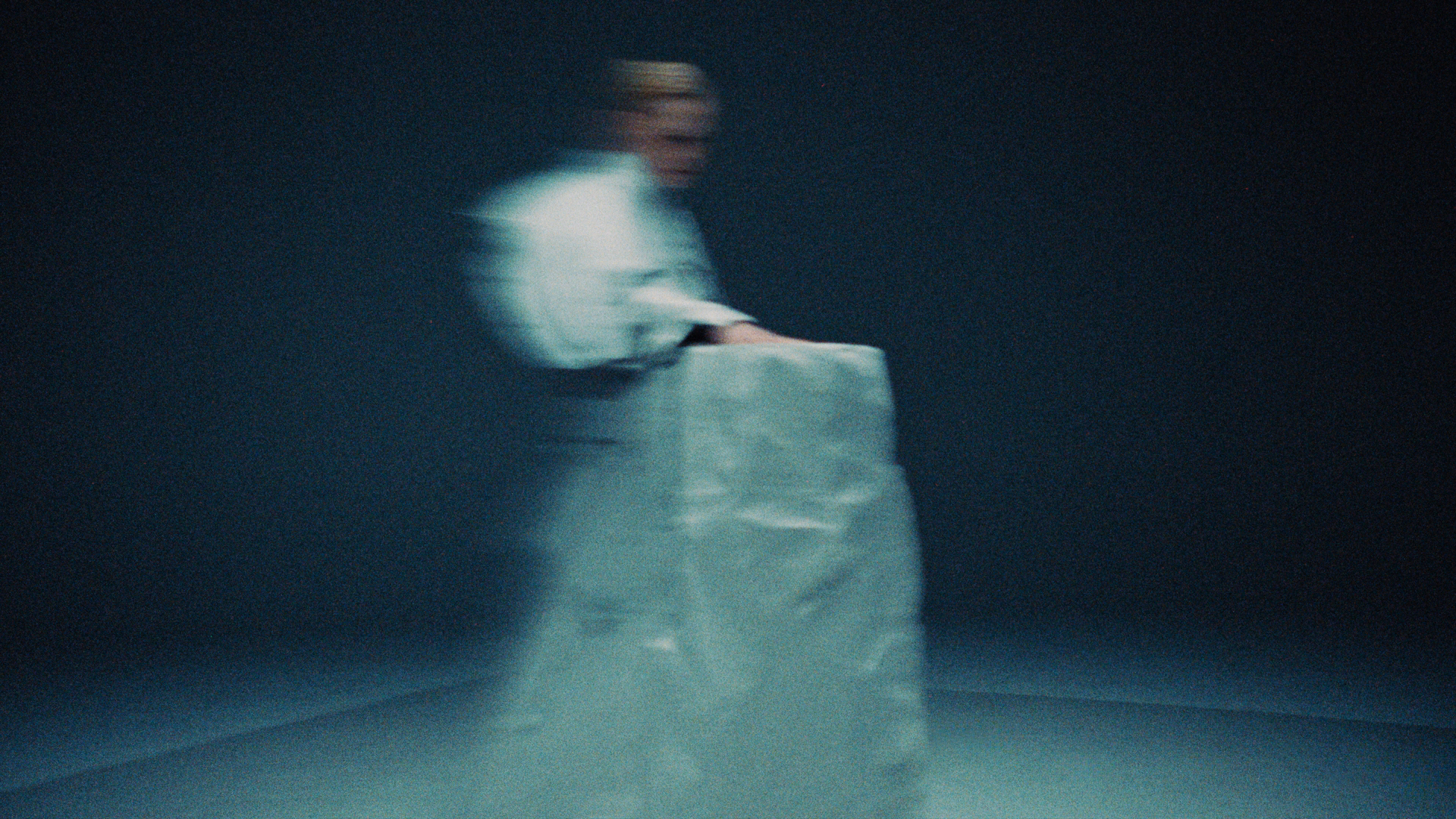 Model in white walking in motion blur.
