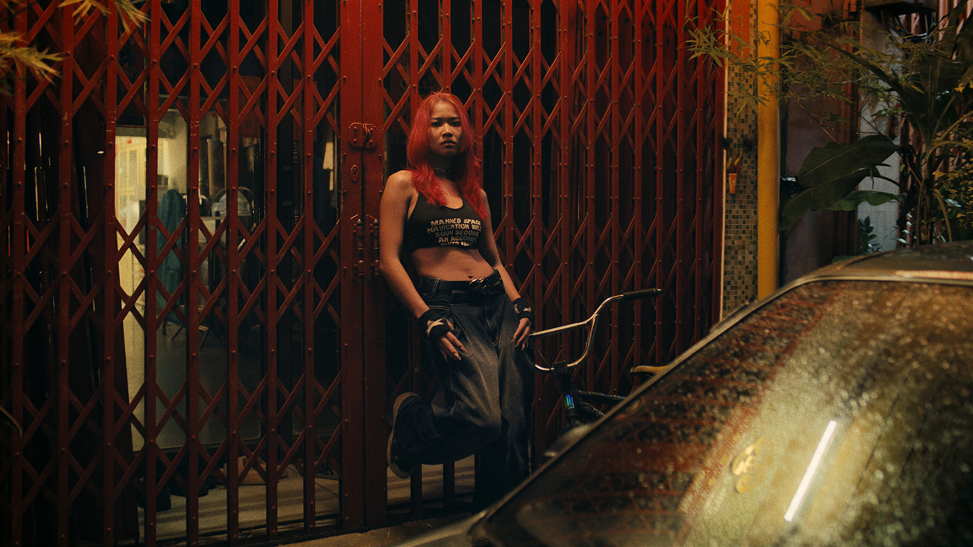 Rita-Ora-x-Tiago-PZK-x-Robin-Schulz-Ill-Be-There-fence-by-Robert-Wunsch Girl standing in front of red fence.