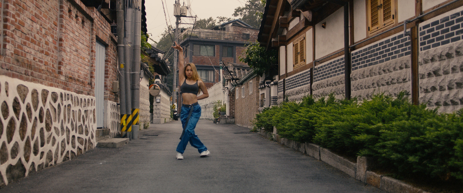 Robin-Schulz-Ft-Wes-Alane-dance-street Girl dancing in the middle of a street with tiled houses.