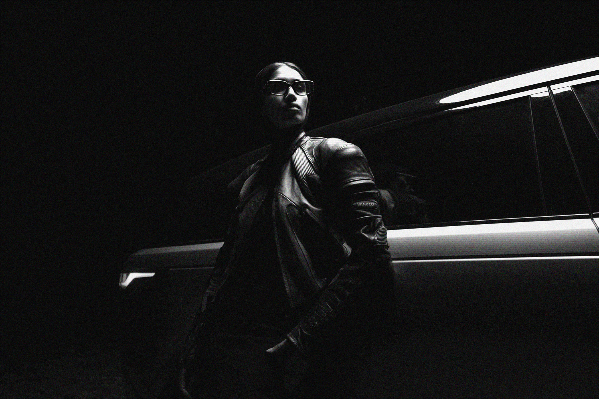 Robert-Wunsch-portfolio-range-rover-MFPA-campaign-leather-jacket_bw Girl in a black leather jacket turning to the light next to a Range Rover Velar.